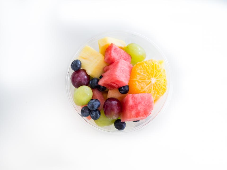 A bowl of colourful fresh fruit on white