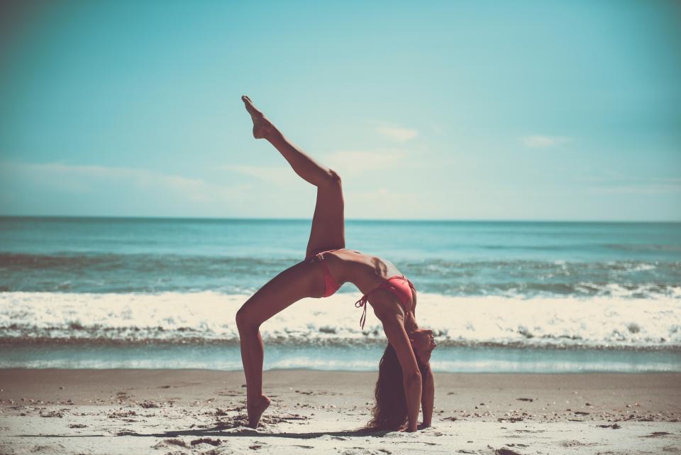 A yoga pose on the beach at the water's edge