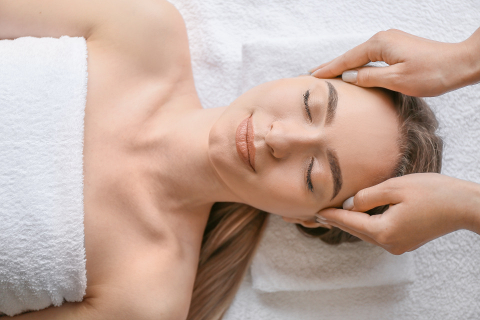 A relaxing face massage on white towels