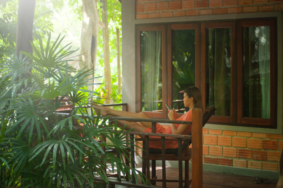 A timber balcony wrapped in tropical greenery